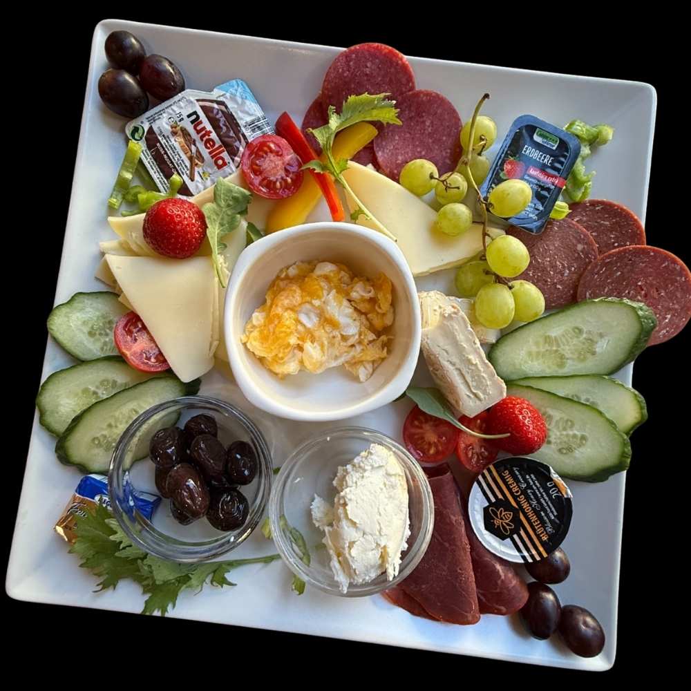 Frühstücksteller mit Käse, Aufschnitt, Früchten und frischem Brot bei Toast Brothers Berlin